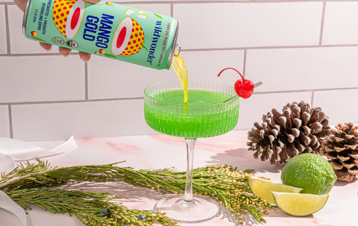 Green mocktail for the grinch made with Mango Gold wildwonder topped with red cherry