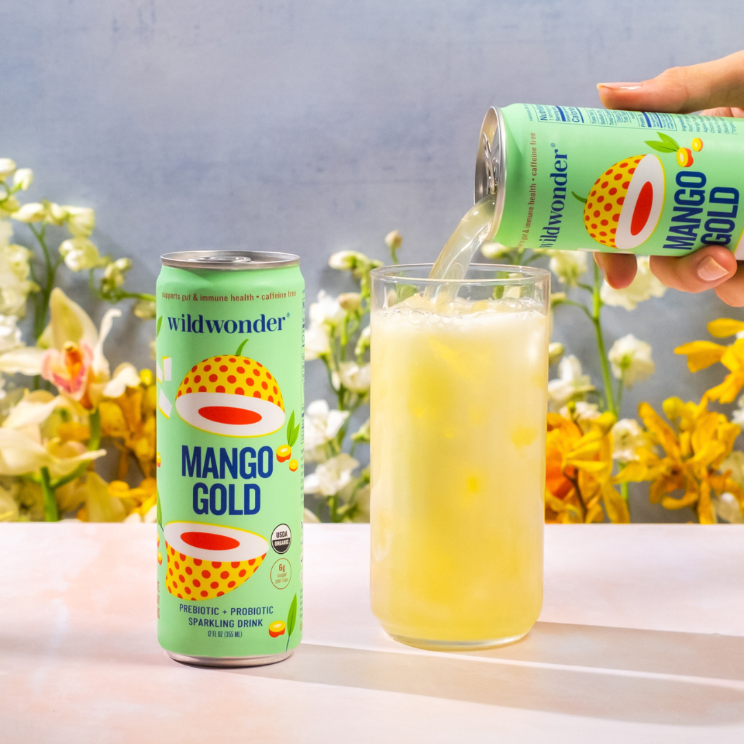 Mango Gold Sparkling Prebiotic + Probiotic drink being poured into a glass.