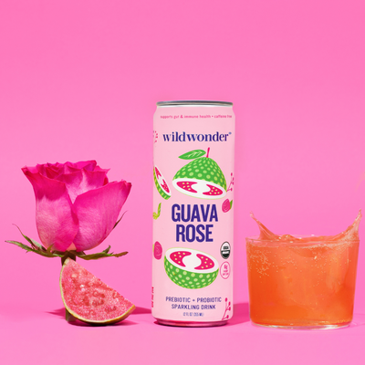 A can of Guava Rose next to a poured glass, with a  guava and rose.